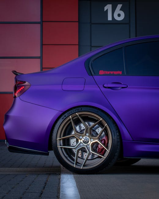 Sleek side view of a purple BMW M3 F80 parked at a modern building with orange panels in England.